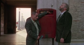 Movie still from “The Belly of an Architect” (1987), directed by Peter Greenaway – Two men in business suits standing next to each other; Medium shot, Low angle