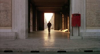 Movie still from “The Belly of an Architect” (1987), directed by Peter Greenaway – A man is walking down the street in a tunnel; Extreme Wide shot, Low angle