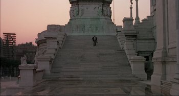 Movie still from “The Belly of an Architect” (1987), directed by Peter Greenaway – A person riding a bike down a set of stairs; Extreme Wide shot, Low angle