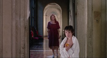 Movie still from “The Belly of an Architect” (1987), directed by Peter Greenaway – A woman and a child in a hallway; Wide shot, Over the shoulder angle