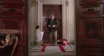 Movie still from “The Belly of an Architect” (1987), directed by Peter Greenaway – An older man standing in front of a young boy; Wide shot, Low angle