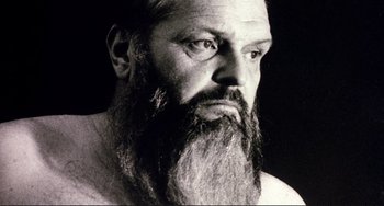 Movie still from “The Belly of an Architect” (1987), directed by Peter Greenaway – A man with a long beard is looking at the camera; Close Up shot, Low angle