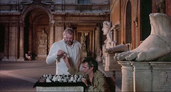 Movie still from “The Belly of an Architect” (1987), directed by Peter Greenaway – Two men are looking at a statue in a museum; Wide shot, Low angle