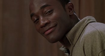 Movie still from “The Best Man” (1999), directed by Malcolm D. Lee – A person wearing a brown shirt smiling; Close Up shot, Low angle