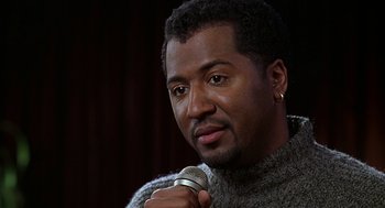 Movie still from “The Best Man” (1999), directed by Malcolm D. Lee – A person holding a microphone; Close Up shot, Over the shoulder angle