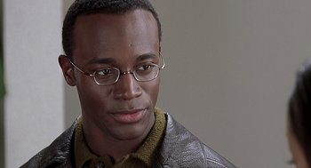 Movie still from “The Best Man” (1999), directed by Malcolm D. Lee – A person wearing glasses and a leather jacket; Close Up shot, Over the shoulder angle