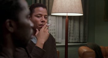 Movie still from “The Best Man” (1999), directed by Malcolm D. Lee – A man sitting in front of a lamp smoking a cigarette; Close Up shot, Over the shoulder angle