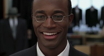 Movie still from “The Best Man” (1999), directed by Malcolm D. Lee – A person wearing a suit and glasses; Close Up shot, Low angle
