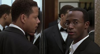 Movie still from “The Best Man” (1999), directed by Malcolm D. Lee – A man in a suit looking at himself in the mirror; Close Up shot, Over the shoulder angle