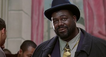Movie still from “The Best Man” (1999), directed by Malcolm D. Lee – A person wearing a hat and a tie; Close Up shot, Low angle