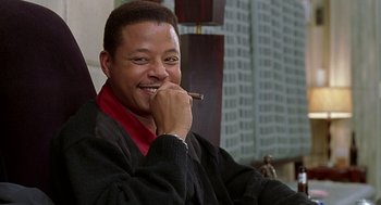 Movie still from “The Best Man” (1999), directed by Malcolm D. Lee – A man sitting in a chair with a cigar in his mouth; Close Up shot, Low angle