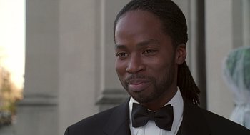 Movie still from “The Best Man” (1999), directed by Malcolm D. Lee – A person wearing a suit and a bow tie; Close Up shot, High angle