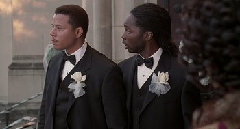 Movie still from “The Best Man” (1999), directed by Malcolm D. Lee – Two men in tuxedos standing next to each other in front of a building; Medium shot, Low angle