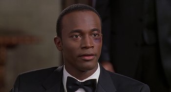 Movie still from “The Best Man” (1999), directed by Malcolm D. Lee – A person wearing a suit and a bow tie; Close Up shot, High angle