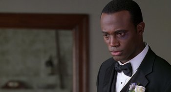 Movie still from “The Best Man” (1999), directed by Malcolm D. Lee – A man in a black suit and bow tie looking to his left; Close Up shot, Over the shoulder angle