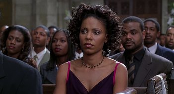 Movie still from “The Best Man” (1999), directed by Malcolm D. Lee – A woman sitting in front of a group of people; Close Up shot, Over the shoulder angle
