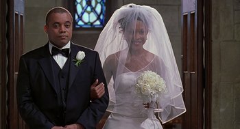 Movie still from “The Best Man” (1999), directed by Malcolm D. Lee – A man and a woman standing in front of a stained glass window; Medium shot, Over the shoulder angle