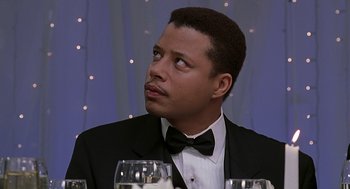 Movie still from “The Best Man” (1999), directed by Malcolm D. Lee – A person sitting at a table wearing a tuxedo; Close Up shot, Low angle