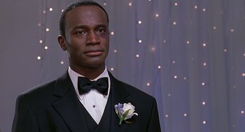 Movie still from “The Best Man” (1999), directed by Malcolm D. Lee – A man wearing a tuxedo and a bow tie; Close Up shot, Over the shoulder angle