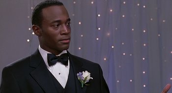 Movie still from “The Best Man” (1999), directed by Malcolm D. Lee – A man in a suit and bow tie; Close Up shot, Over the shoulder angle