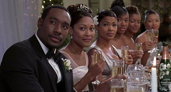 Movie still from “The Best Man” (1999), directed by Malcolm D. Lee – A group of people sitting at a table holding champagne glasses; Close Up shot, Over the shoulder angle