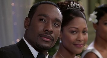 Movie still from “The Best Man” (1999), directed by Malcolm D. Lee – A man and a woman posing for a picture; Close Up shot, Low angle
