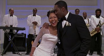 Movie still from “The Best Man” (1999), directed by Malcolm D. Lee – A bride and a groom kissing each other at their wedding; Medium shot, Low angle