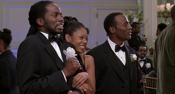 Movie still from “The Best Man” (1999), directed by Malcolm D. Lee – A group of young people in tuxedos at an event; Medium shot, Over the shoulder angle