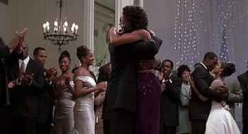 Movie still from “The Best Man” (1999), directed by Malcolm D. Lee – Two people hugging each other in front of a group of people; Medium shot, Over the shoulder angle