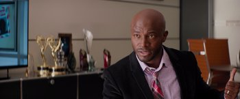 Movie still from “The Best Man Holiday” (2013), directed by Malcolm D. Lee – A man in a suit and tie in a room; Close Up shot, Over the shoulder angle