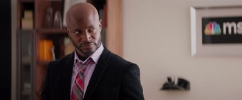 Movie still from “The Best Man Holiday” (2013), directed by Malcolm D. Lee – A man wearing a suit and tie standing in front of a wall; Close Up shot, Over the shoulder angle