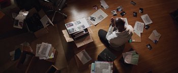 Movie still from “The Best Man Holiday” (2013), directed by Malcolm D. Lee – A man sitting on the floor surrounded by papers; Wide shot, Overhead angle