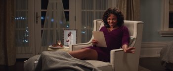 Movie still from “The Best Man Holiday” (2013), directed by Malcolm D. Lee – A woman sitting in a chair reading a letter; Medium shot, Over the shoulder angle