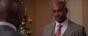 Movie still from “The Best Man Holiday” (2013), directed by Malcolm D. Lee – A man wearing a suit and tie in a room; Close Up shot, Over the shoulder angle