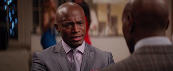 Movie still from “The Best Man Holiday” (2013), directed by Malcolm D. Lee – A man in a suit and tie looking at the camera; Close Up shot, Over the shoulder angle