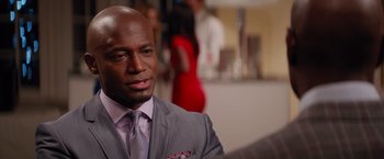 Movie still from “The Best Man Holiday” (2013), directed by Malcolm D. Lee – A man wearing a suit and tie in front of a mirror; Close Up shot, Over the shoulder angle