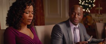 Movie still from “The Best Man Holiday” (2013), directed by Malcolm D. Lee – A man and a woman sitting next to each other on a couch; Medium shot, Over the shoulder angle