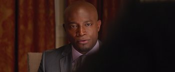 Movie still from “The Best Man Holiday” (2013), directed by Malcolm D. Lee – A man in a suit and tie looking at the camera; Close Up shot, Over the shoulder angle