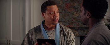 Movie still from “The Best Man Holiday” (2013), directed by Malcolm D. Lee – A man in a robe holding a tablet; Close Up shot, Over the shoulder angle