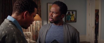 Movie still from “The Best Man Holiday” (2013), directed by Malcolm D. Lee – A man in a blue t - shirt is looking at another man in a gray shirt; Close Up shot, Over the shoulder angle