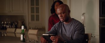 Movie still from “The Best Man Holiday” (2013), directed by Malcolm D. Lee – A man reading a book while sitting at a table; Close Up shot, Over the shoulder angle