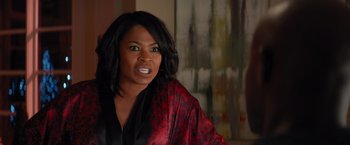 Movie still from “The Best Man Holiday” (2013), directed by Malcolm D. Lee – A woman in a black and red robe looking at the camera; Close Up shot, Over the shoulder angle