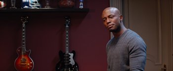 Movie still from “The Best Man Holiday” (2013), directed by Malcolm D. Lee – A man standing in front of an electric guitar in a room; Close Up shot, Over the shoulder angle