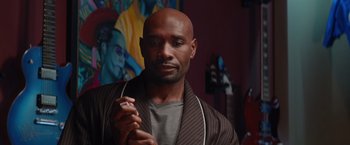 Movie still from “The Best Man Holiday” (2013), directed by Malcolm D. Lee – A man with a beard is holding a cell phone in his hand; Close Up shot, Over the shoulder angle