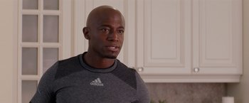 Movie still from “The Best Man Holiday” (2013), directed by Malcolm D. Lee – A man with a bald head wearing a gray shirt; Close Up shot, Over the shoulder angle