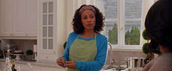 Movie still from “The Best Man Holiday” (2013), directed by Malcolm D. Lee – A woman wearing an apron in a kitchen; Medium shot, Over the shoulder angle