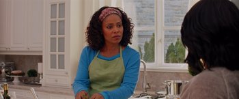 Movie still from “The Best Man Holiday” (2013), directed by Malcolm D. Lee – A woman sitting at a kitchen counter holding a knife; Medium shot, Over the shoulder angle