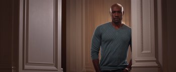 Movie still from “The Best Man Holiday” (2013), directed by Malcolm D. Lee – A man standing in front of a wall with his hands in his pockets; Medium shot, Low angle