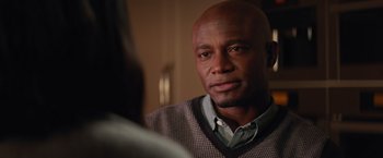 Movie still from “The Best Man Holiday” (2013), directed by Malcolm D. Lee – A bald man wearing a plaid shirt is looking at the camera; Close Up shot, Over the shoulder angle