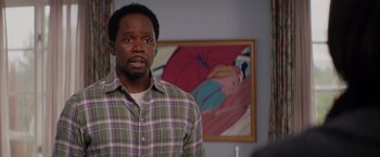 Movie still from “The Best Man Holiday” (2013), directed by Malcolm D. Lee – A man standing in front of a painting in a living room; Medium shot, Over the shoulder angle